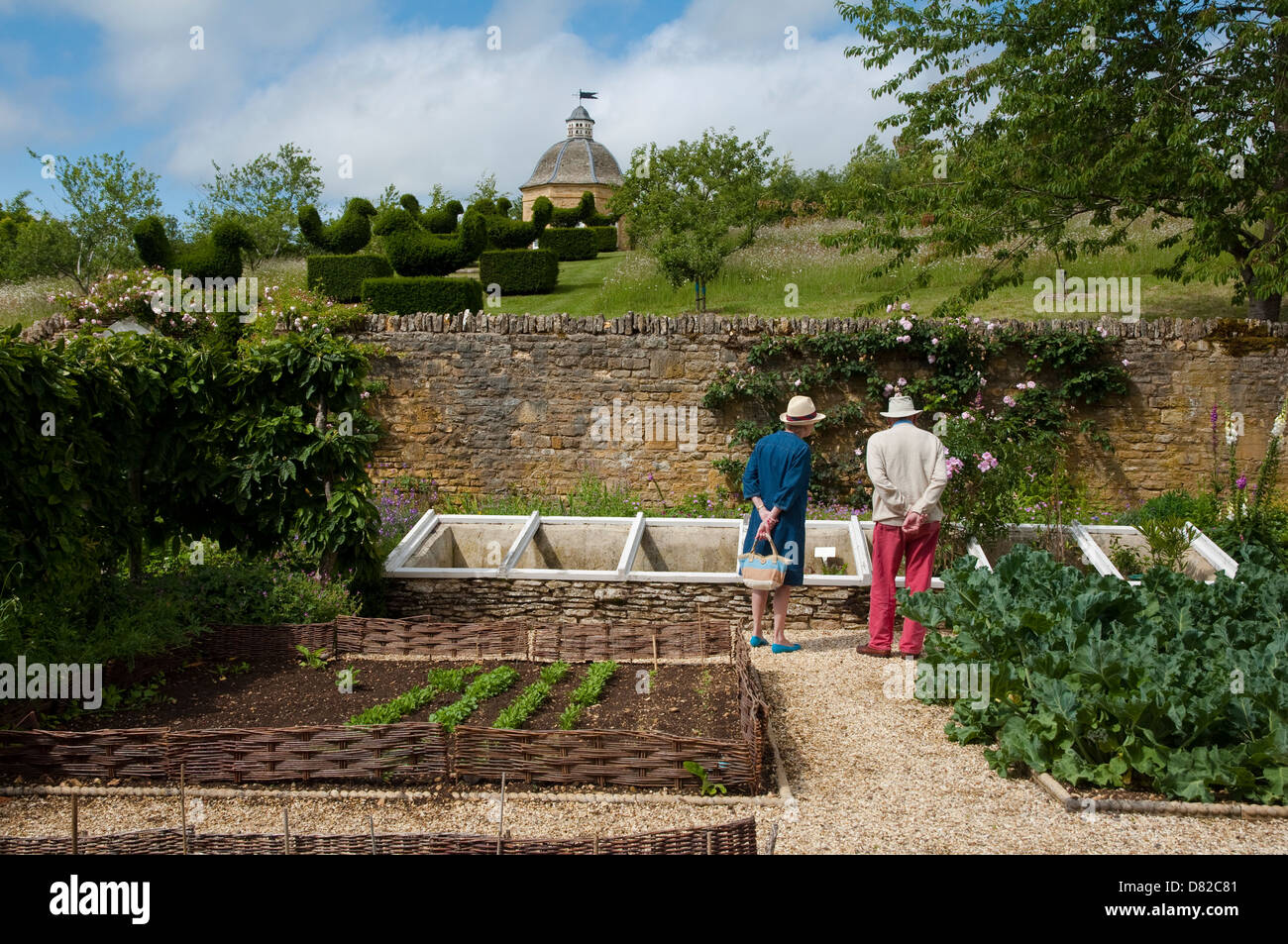 A retired couple admire the vegetable garden and its cold frames at Rockcliffe Garden, Gloucestershire. UK. Stock Photo