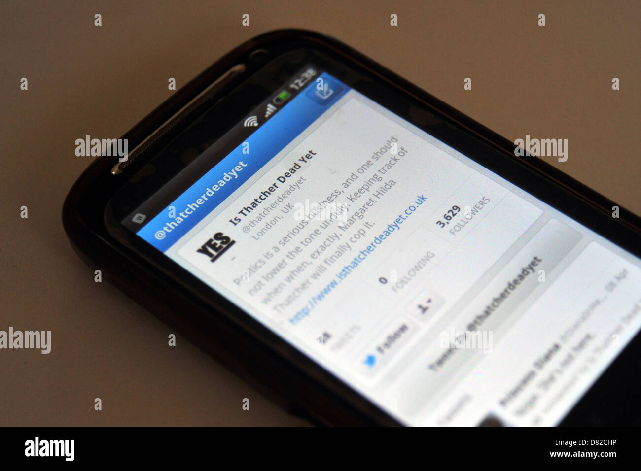 Tweets displayed on a mobile phone screen following the death and funeral of former British Prime Minister Margaret Thatcher. Stock Photo