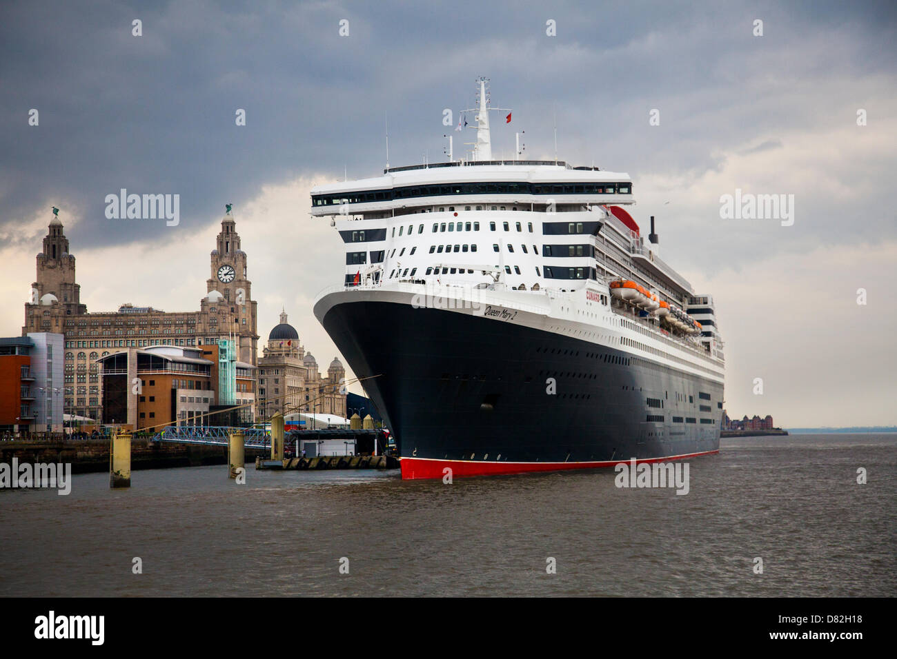 Liverpool, UK 17th May, 2013. The Big Cruise Liner Terminal where the Passenger ship registered in Bermuda Liner RMS Queen Mary 2 berthed on her visit to the City.  The Liverpool Cruise Terminal is a 350-metre-long floating structure situated on the River Mersey enabling large cruise ships to visit without entering the enclosed dock system or berthing mid-river and tendering passengers ashore. The terminal was officially opened on 21 September 2007 by HRH The Duke of Kent when the Queen Elizabeth 2 berthed at the Prince's Dock terminal. Stock Photo