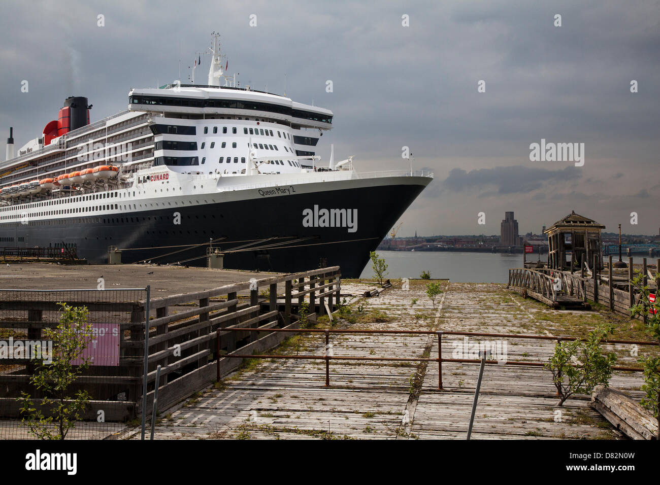Liverpool, UK 17th May, 2013. The Big Cruise Liner Terminal where the Passenger ship registered in Bermuda Liner RMS Queen Mary 2 berthed on her visit to the City.  The Liverpool Cruise Terminal is a 350-metre-long floating structure situated on the River Mersey enabling large cruise ships to visit without entering the enclosed dock system or berthing mid-river and tendering passengers ashore. The terminal was officially opened on 21 September 2007 by HRH The Duke of Kent when the Queen Elizabeth 2 berthed at the terminal. Stock Photo
