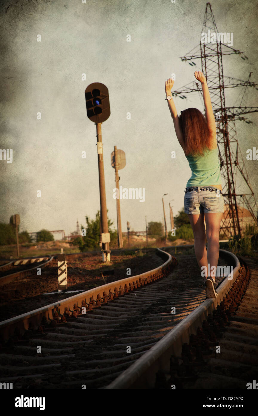 girl walking alone along ra track, image in grunge style Stock Photo