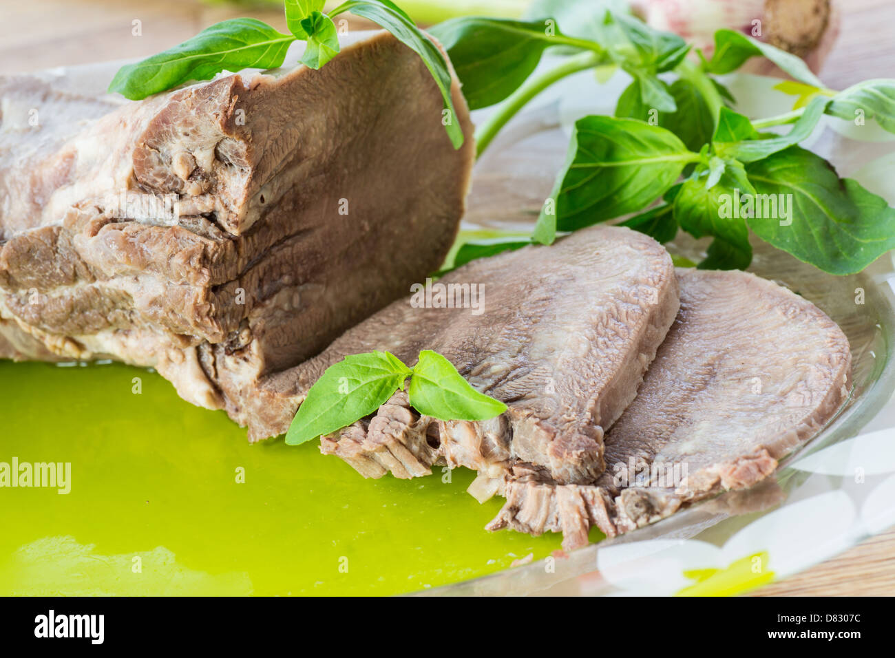 Boiled beef tongue with a sprig of basil Stock Photo Alamy