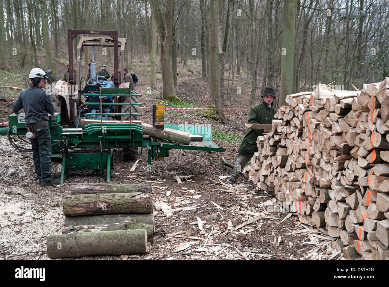 Processing firewood logs with a tractor mounted splitter Stock Photo