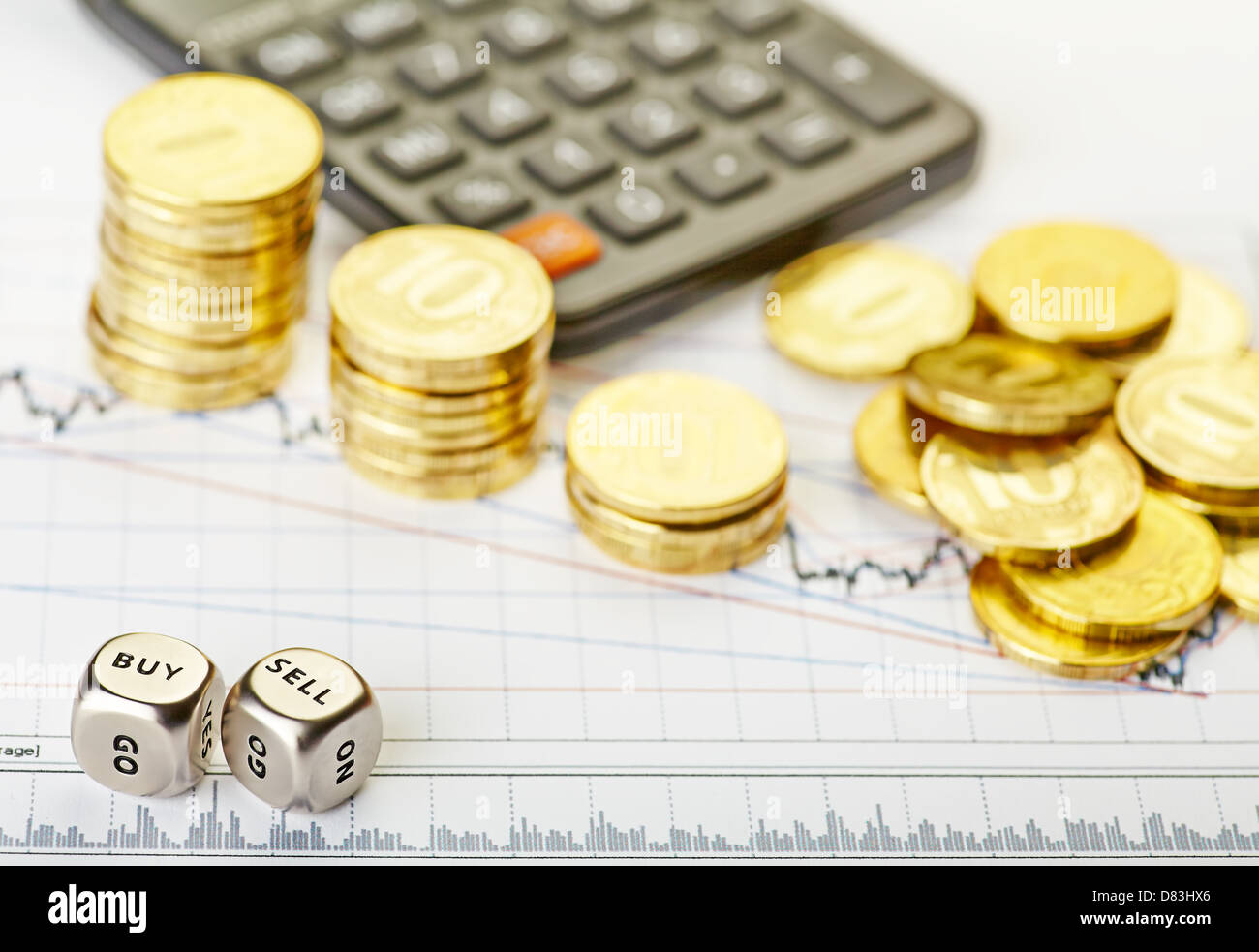 Downtrend stacks of golden coins, dices cubes with the words SELL BUY, calculator on the financial stock charts. Selective focus Stock Photo