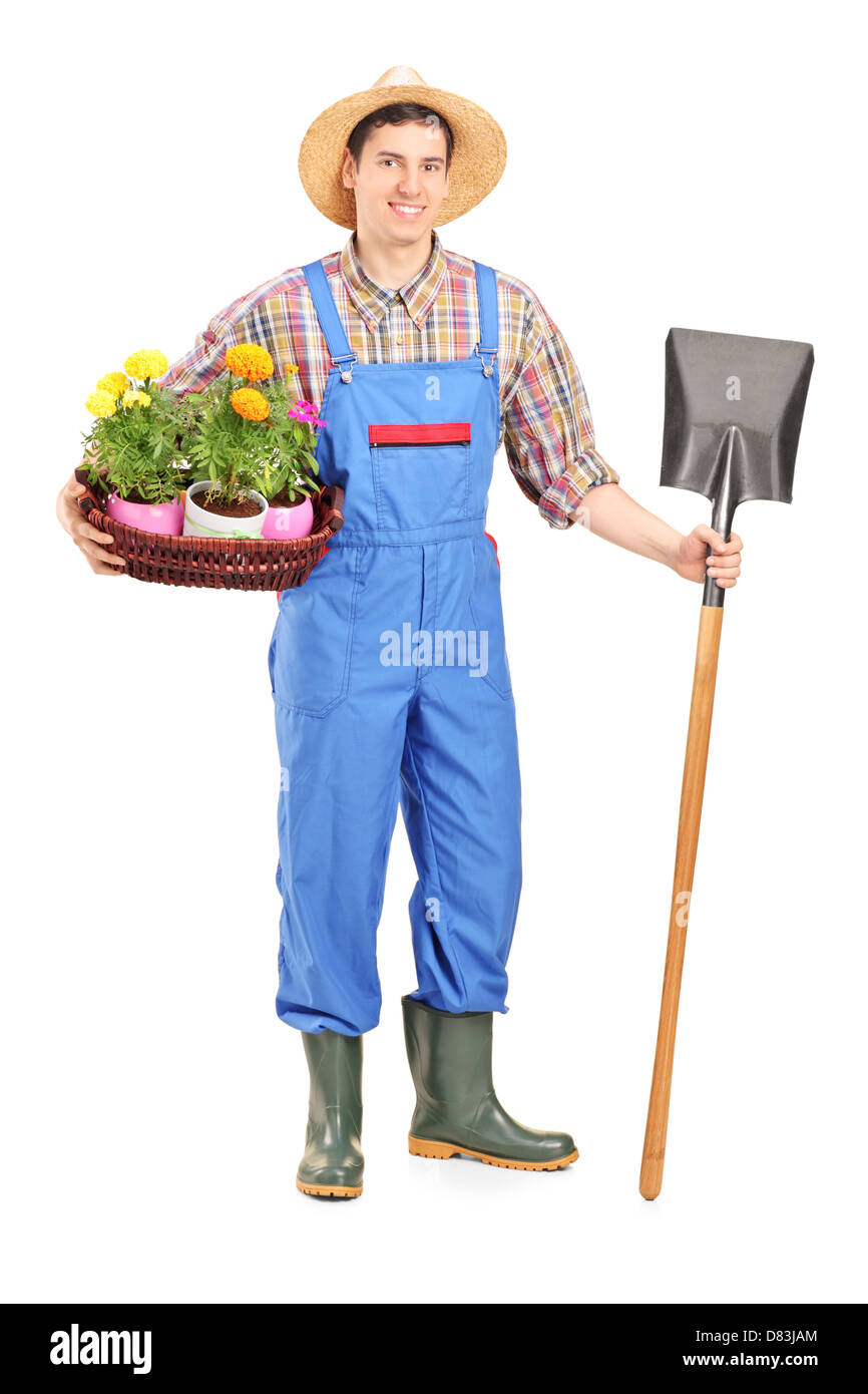 Full length portrait of a male agricultural worker holding a shovel and ...