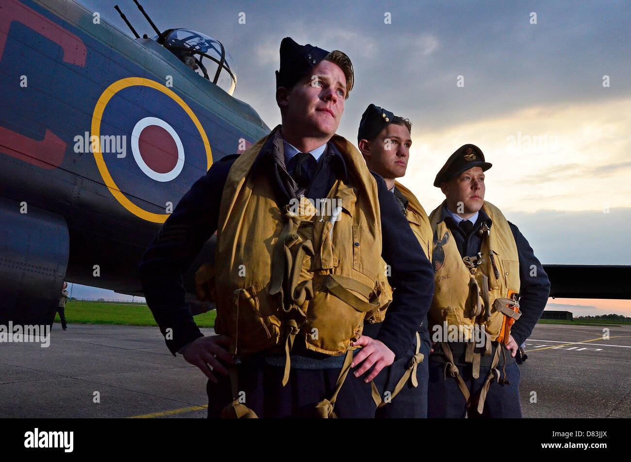 RAF Scampton, Lincolnshire, UK. 16th May 2013. WWII re-enactors Richard Bass, Dean Bryan and Vincent Scopes with B of B memorial Lancaster Bomber at RAF Scampton, Lincs., for the sunset memorial, 16-May-2013. Photo by John Robertson/Alamy Live News Stock Photo