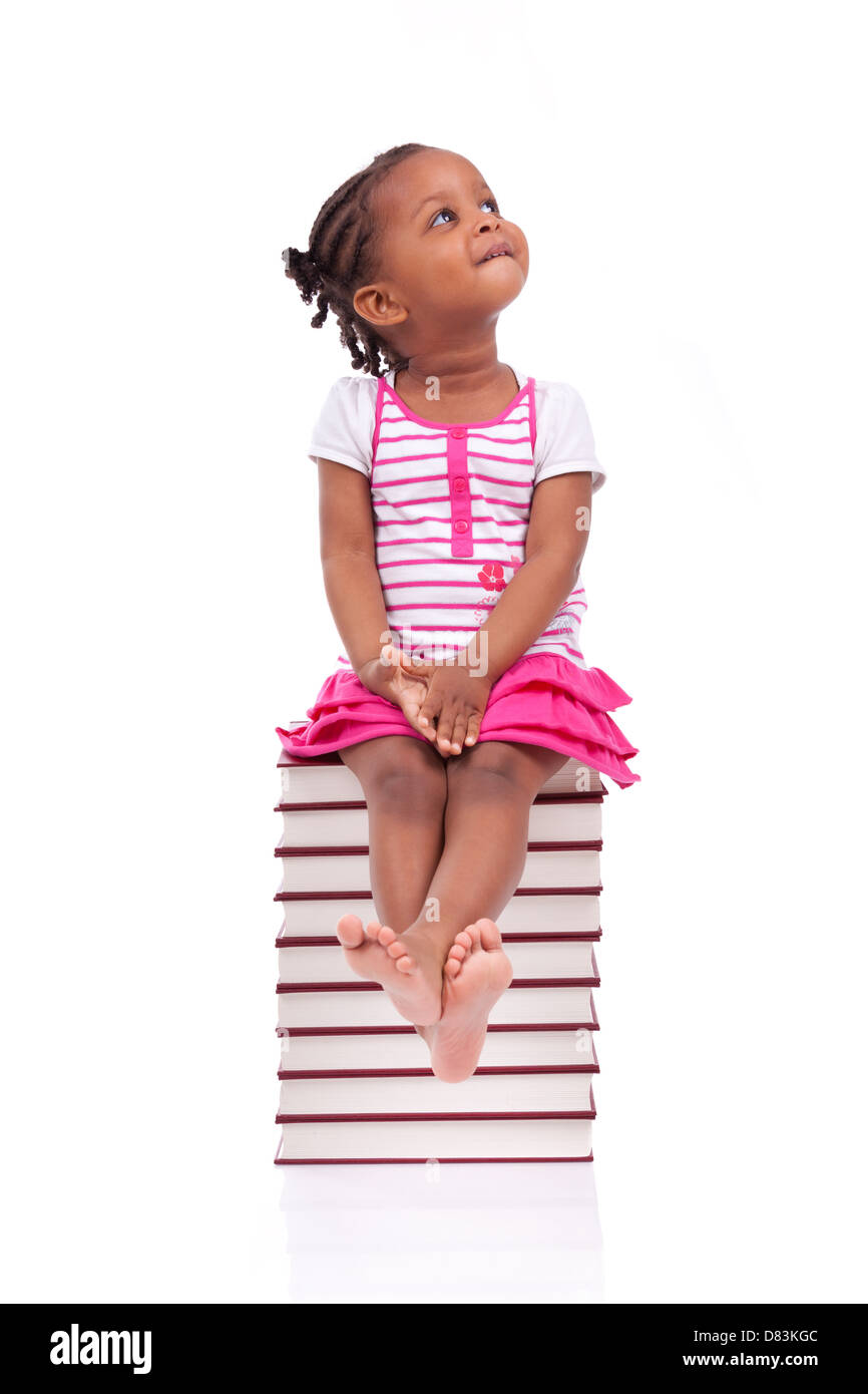 Cute black african american little girl seated in a stack of books ...