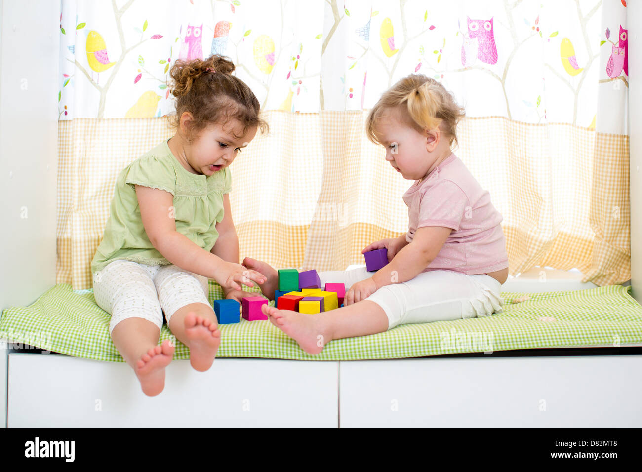children sisters playing together indoors Stock Photo