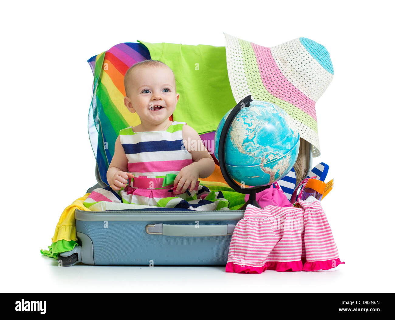 Baby girl sitting in suitcase with things for vacation travel Stock Photo
