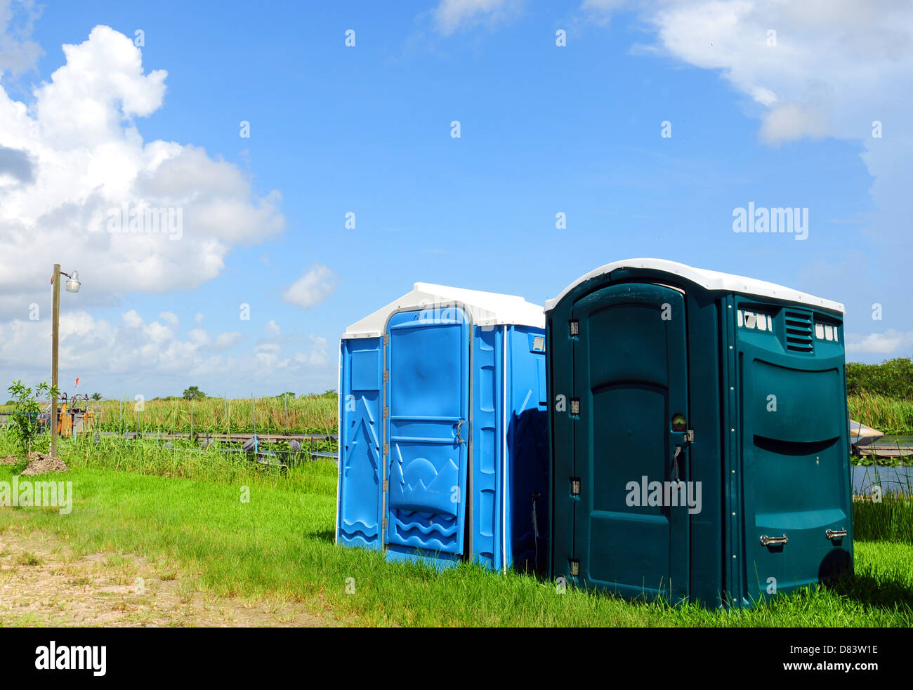 Green and blue outhouses near a river Stock Photo Alamy