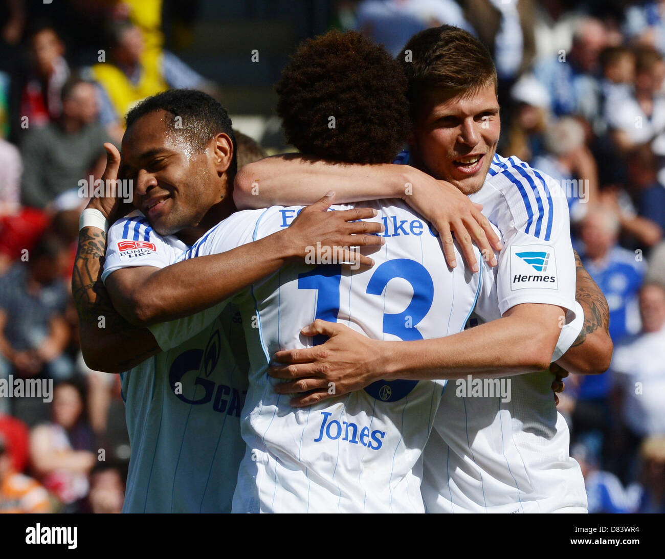 Schalke's Raffael, Jermaine Jones and Klaas-Jan Huntelaar (L-R) cheer after the 2-1 own goal of Freiburg's Schuster during the Bundesliga soccer match between SC Freiburg and FC Schalke 04 at Mage Solar stadium in Freiburg, Germany, 18 May 2013. Photo: PATRICK SEEGER  (ATTENTION: EMBARGO CONDITIONS! The DFL permits the further utilisation of up to 15 pictures only (no sequntial pictures or video-similar series of pictures allowed) via the internet and online media during the match (including halftime), taken from inside the stadium and/or prior to the start of the match. The DFL permits the un Stock Photo