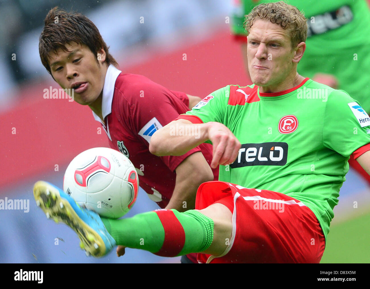 Hanover's Hiroki Sakai (L) vies for the ball with Duesseldorf's Johannes van den Bergh during the Bundesliga soccer match between Hanover 96 and Fortuna Duesseldorf at AWD Arena in Hanover, Germany, 18 May 2013. Photo: PETER STEFFEN (ATTENTION: EMBARGO CONDITIONS! The DFL permits the further utilisation of up to 15 pictures only (no sequntial pictures or video-similar series of pictures allowed) via the internet and online media during the match (including halftime), taken from inside the stadium and/or prior to the start of the match. The DFL permits the unrestricted transmission of digitised Stock Photo