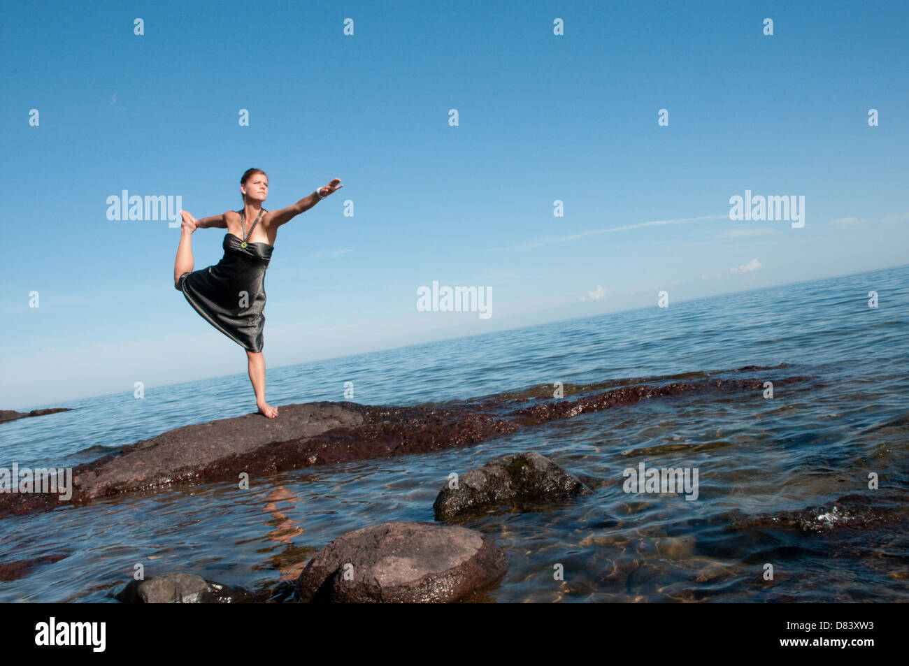 Young woman doing Yoga on North shore of Lake superior Stock Photo