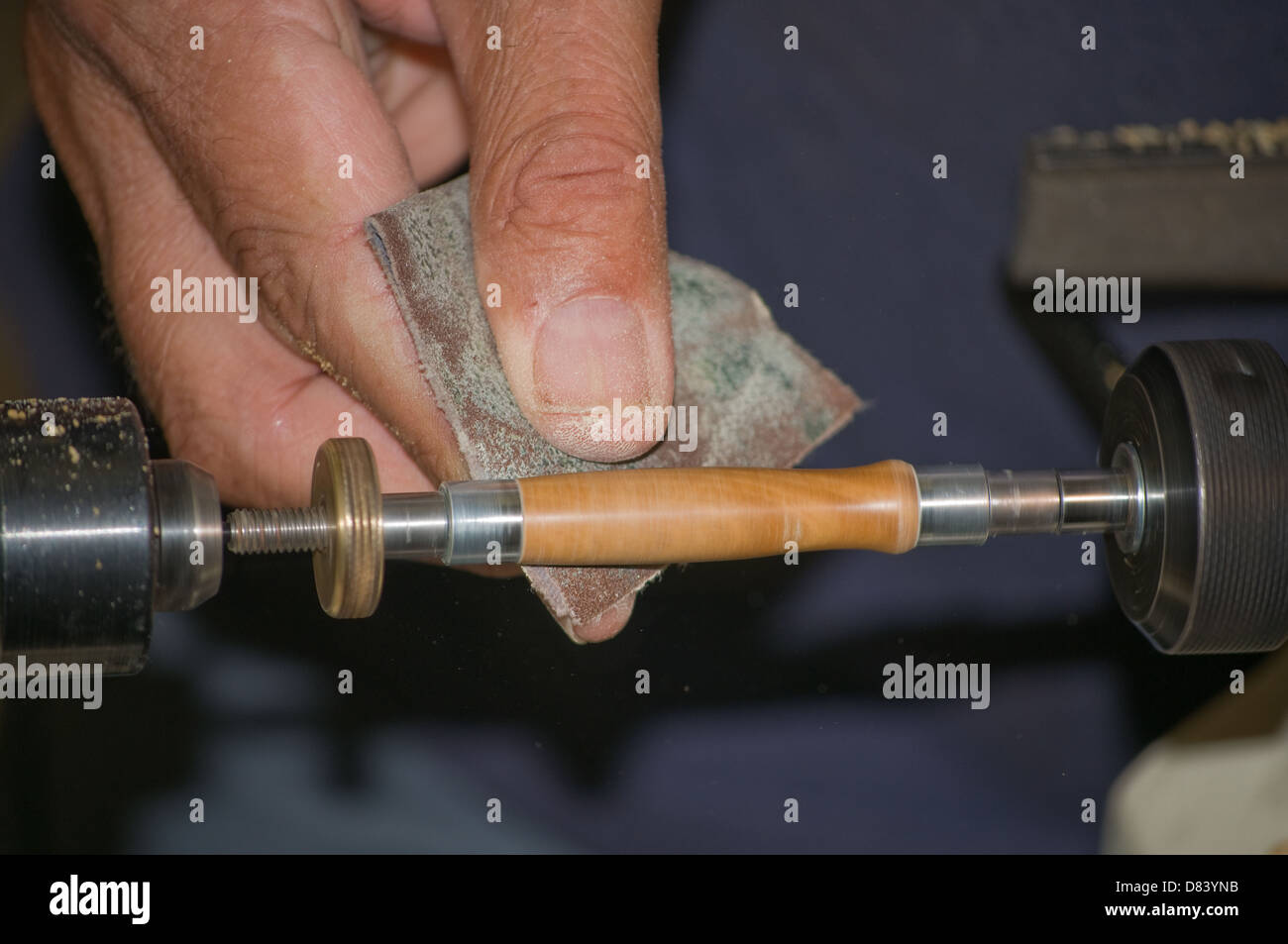 using sandpaper on a lathe to shape a wooden pen Stock Photo Alamy