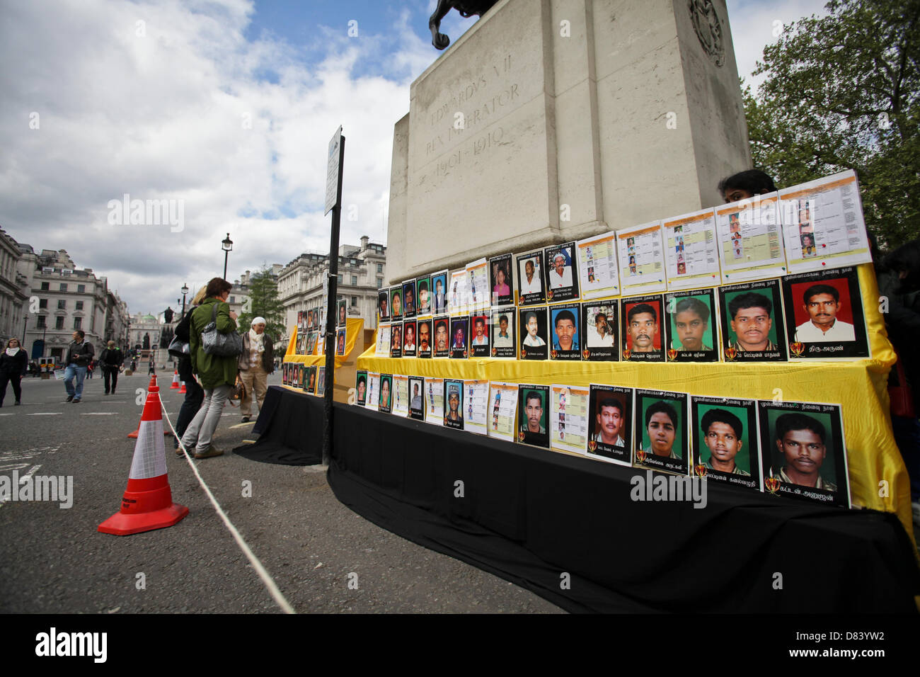 London, UK. 18th May 2013. . Pedestrians look at photographs of Tamils killed during the Sri Lankan civil war. Credit:  Rob Pinney / Alamy Live News Stock Photo