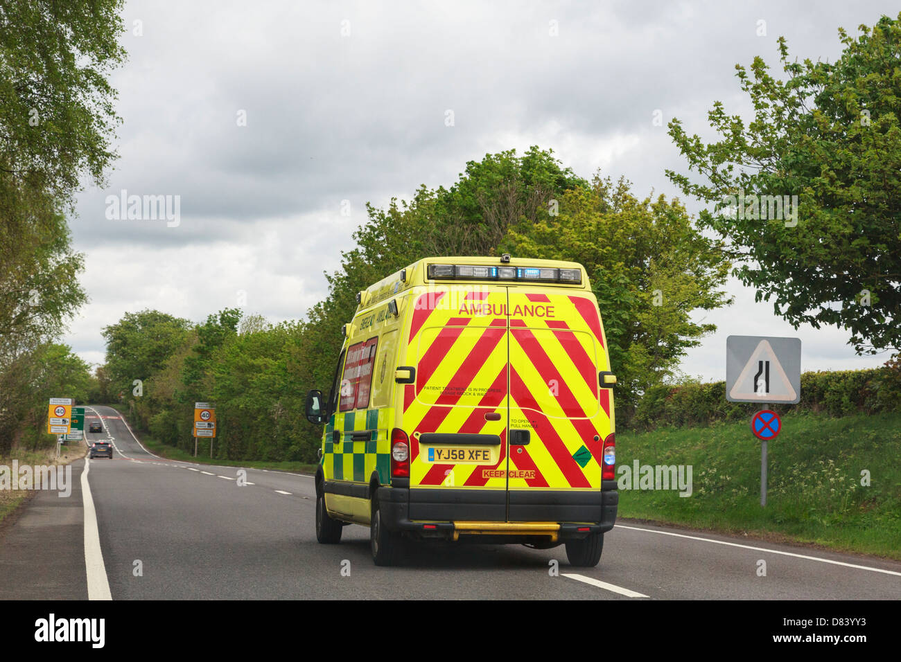 View through a windscreen of an ambulance with blue lights flashing rushing to an emergency along A5 road. England, UK, Britain Stock Photo