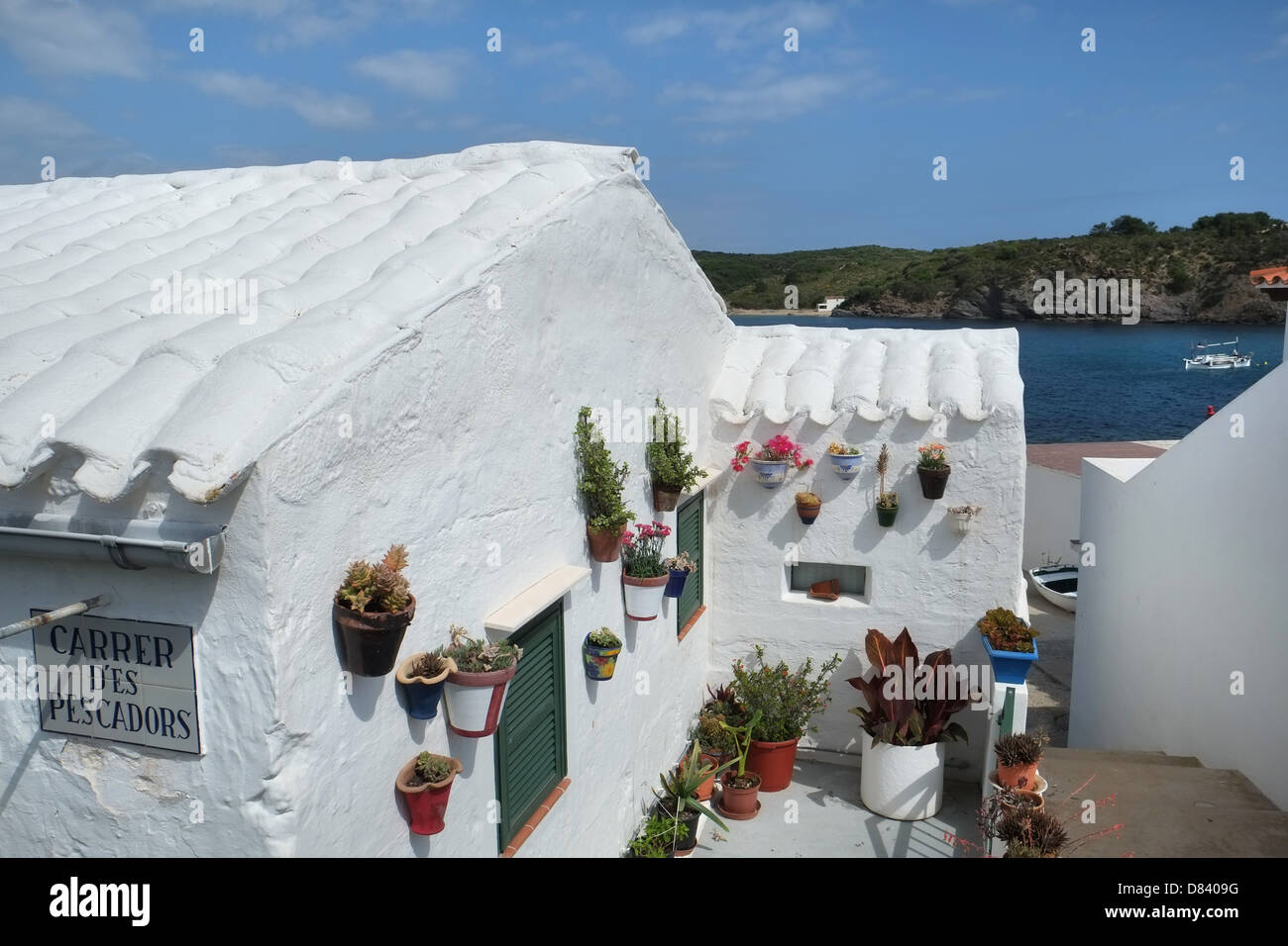 Whitewashed cottage, with pantile roof and flowerpots on wall. Es Grau, Menorca, Balearics, Spain Stock Photo