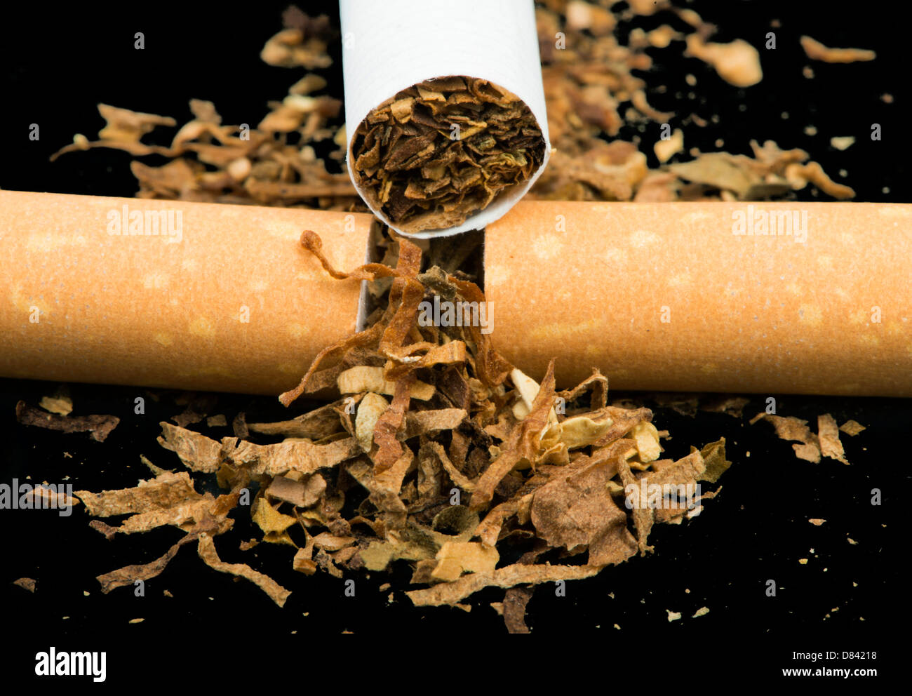 Arranged in a row cigarettes and scattered tabaco Stock Photo