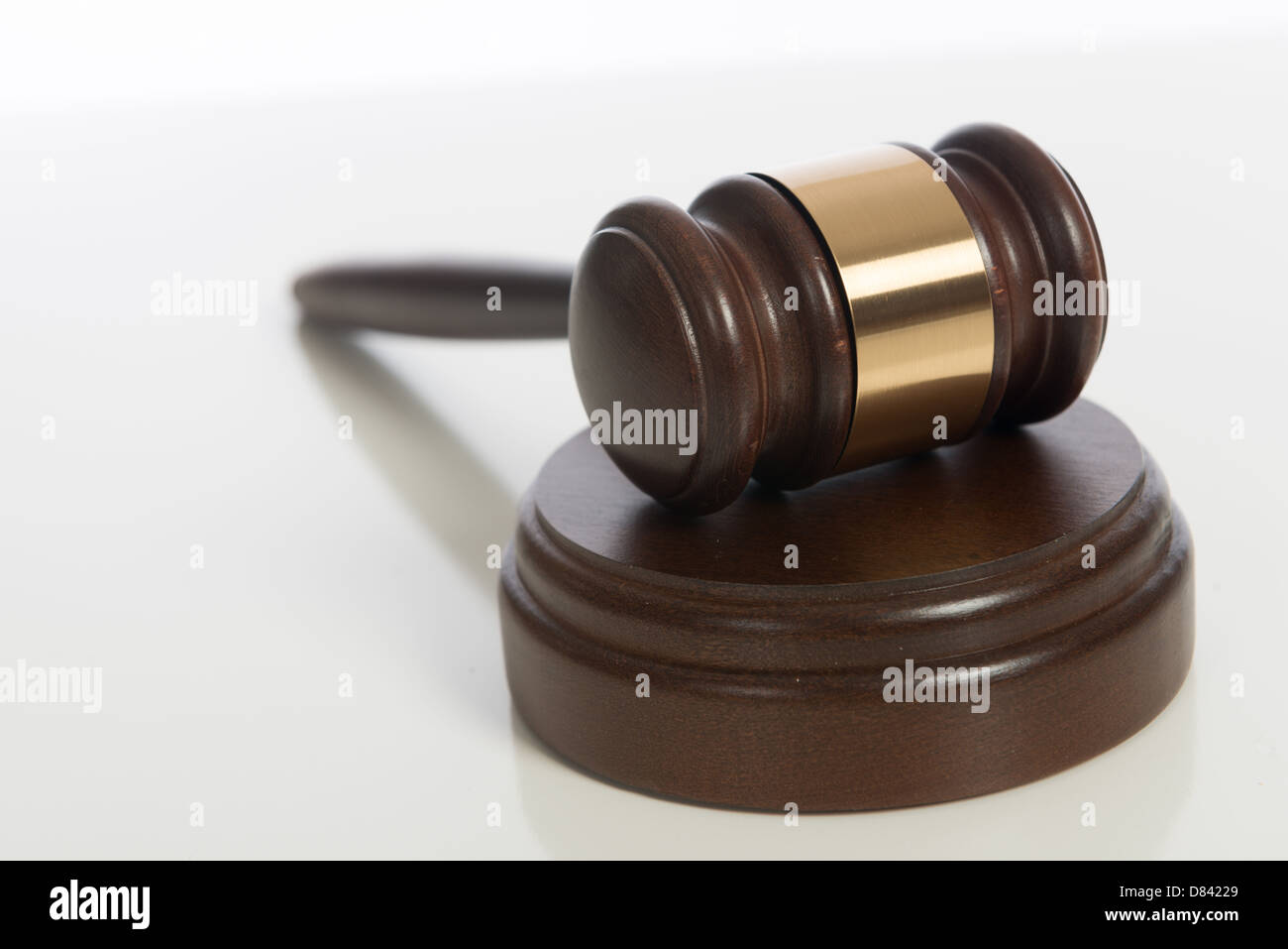 A brown wooden judge's gavel on a white background Stock Photo