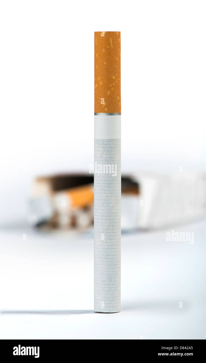 Cigarette on the foreground and many cigarettes on a background Stock