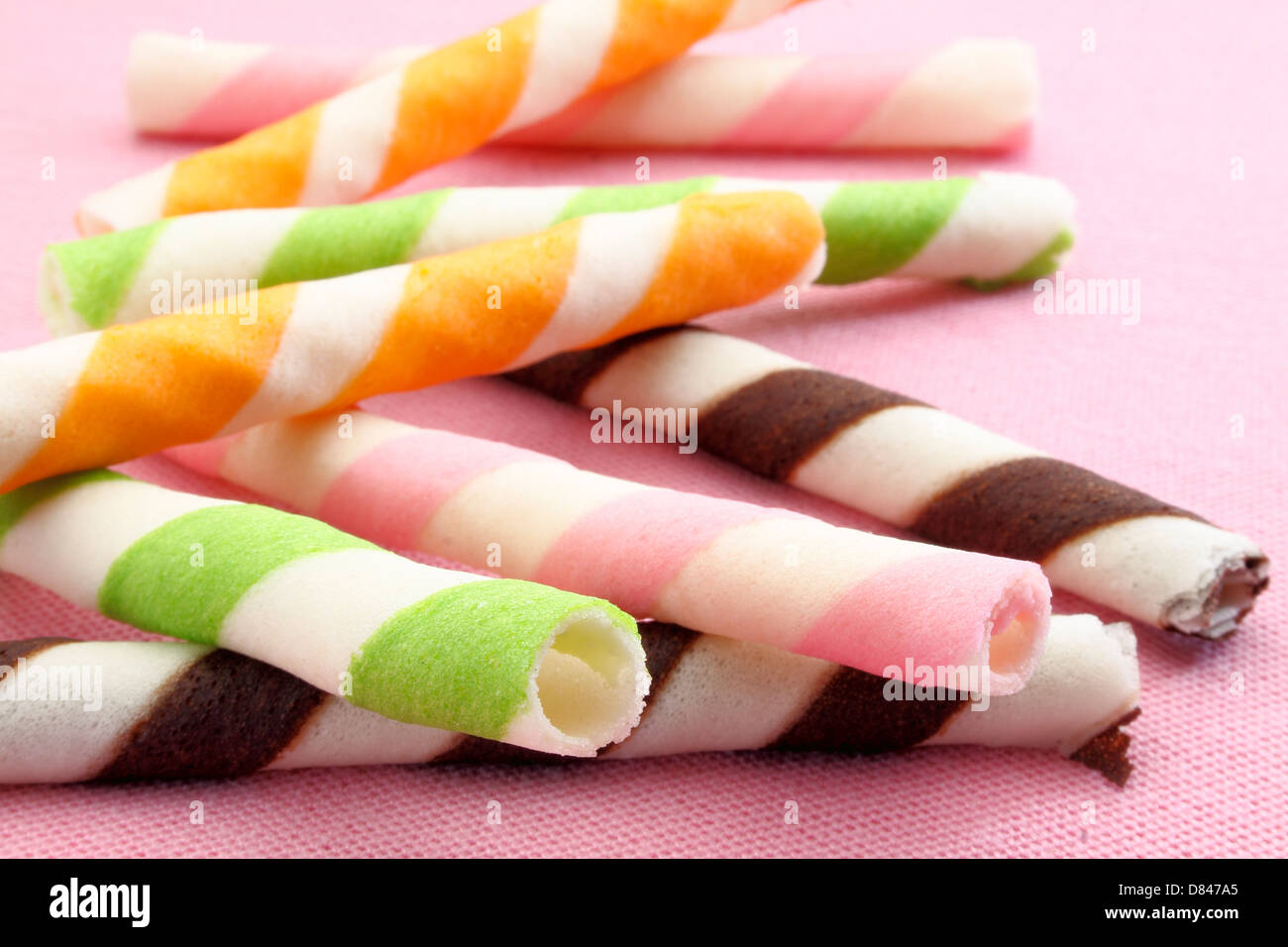 strips wafer roll fill with cream on pink background Stock Photo