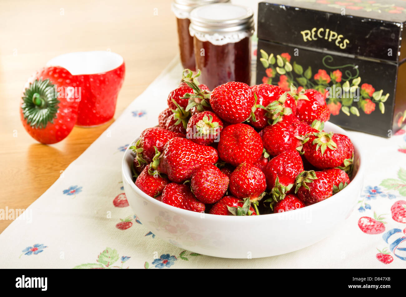 Bowl of fresh strawberries with jam and a recipe box Stock Photo
