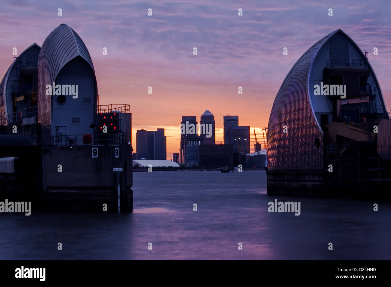 Sunset of the Thames Barrier and Canary Wharf in the distance Stock ...