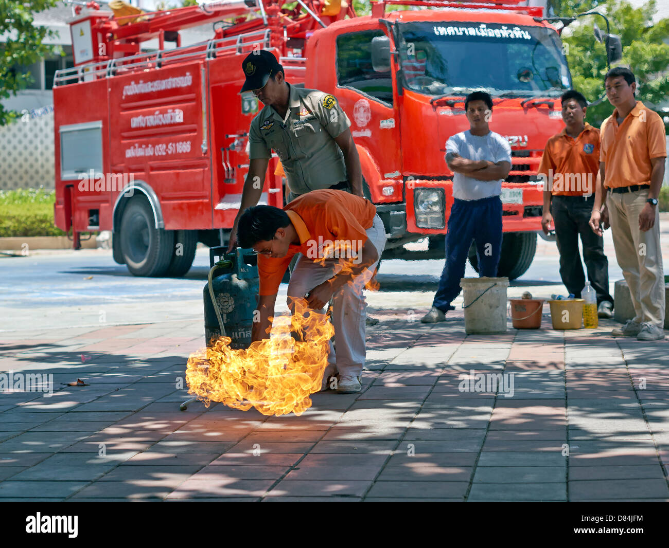 Home appliance fire safety education. Thailand fire officer demonstrating the potential hazard of fire from a domestic propane gas bottle. Stock Photo