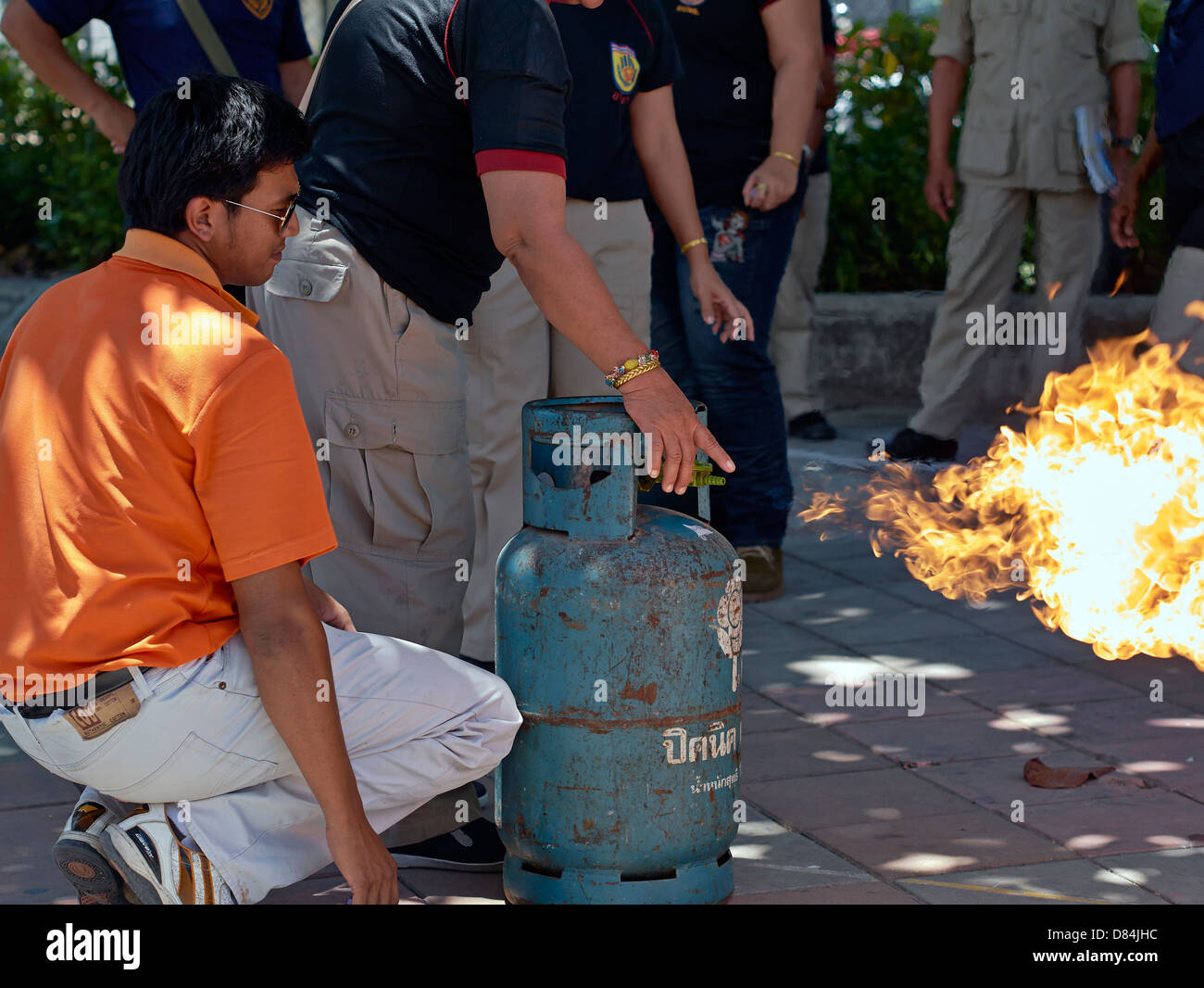 Home appliance fire safety education.Thailand fire officer demonstrating the safe method to extinguish flame from a propane gas bottle. Stock Photo