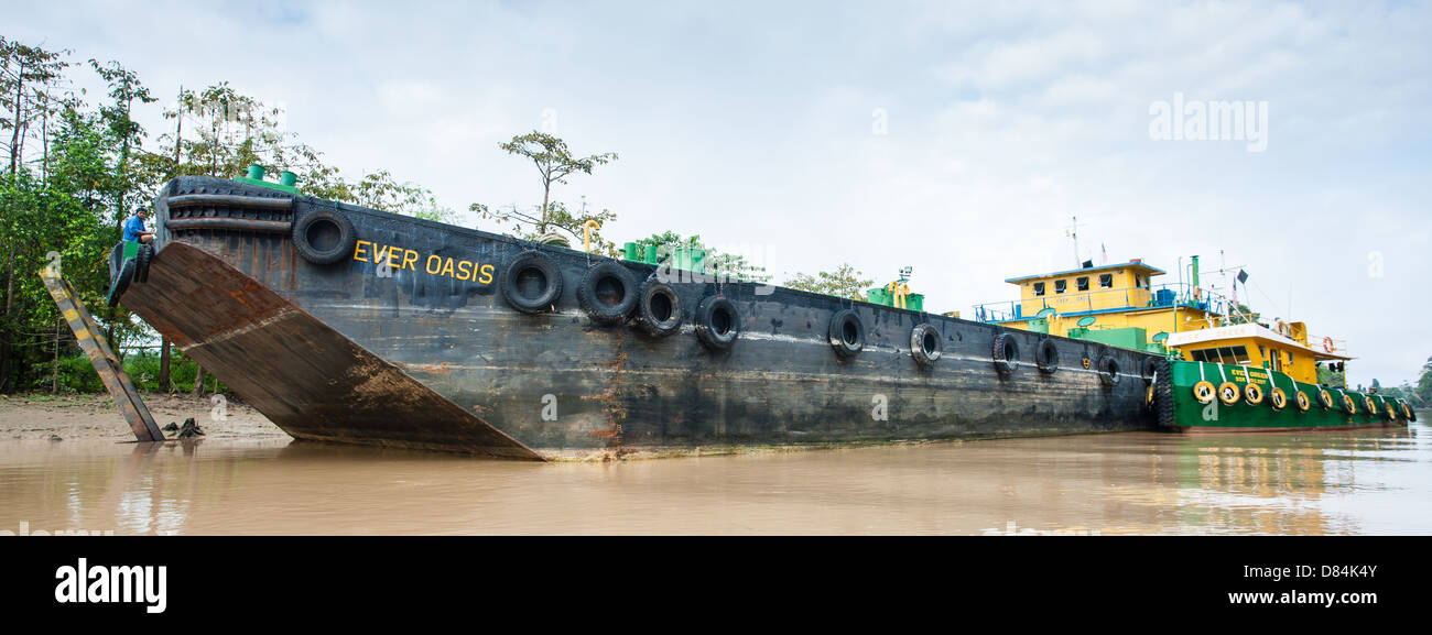 Large palm oil tanker in a narrow creek off the Kinabatangan River in Sabah Borneo transports oil from crushing mill to refinery Stock Photo