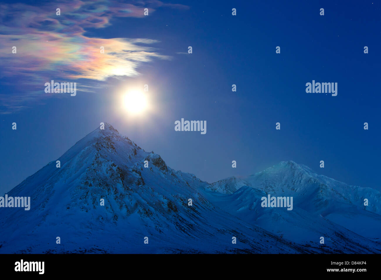 Full moon with rainbow clouds over Ogilvie Mountains, Tombstone Park, Dempster Highway, Canada. Stock Photo