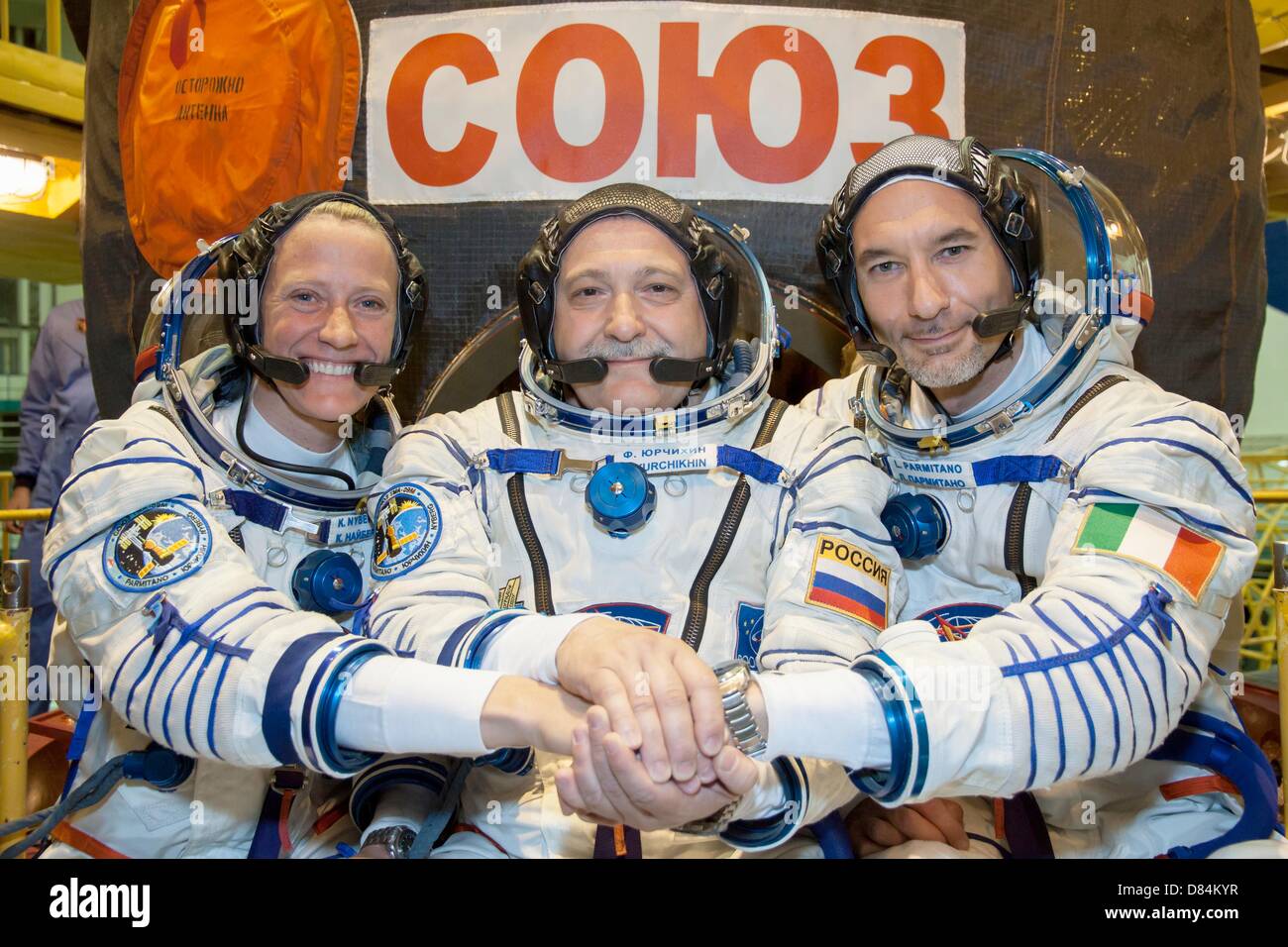 NASA astronaut Karen Nyberg, left, Soyuz Commander Fyodor Yurchikhin, center, and European Space Agency astronaut Luca Parmitano pose for pictures in their Sokol spacesuits during the fit check exercise at the Integration Facility in the Baikonur Cosmodrome May 17, 2013 in Baikonur, Kazakhstan. Parmitano along with NASA astronaut Karen Nyberg and Soyuz Commander Fyodor Yurchikhin will launch May 29 as Expedition crew 36/37 to the International Space Station. Stock Photo