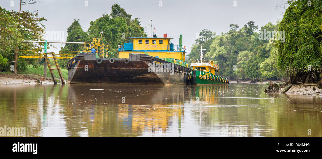 Palm oil tanker in a small creek of the  Kinabatangan River Sabah Borneo transports oil from crushing mill to refinery Stock Photo