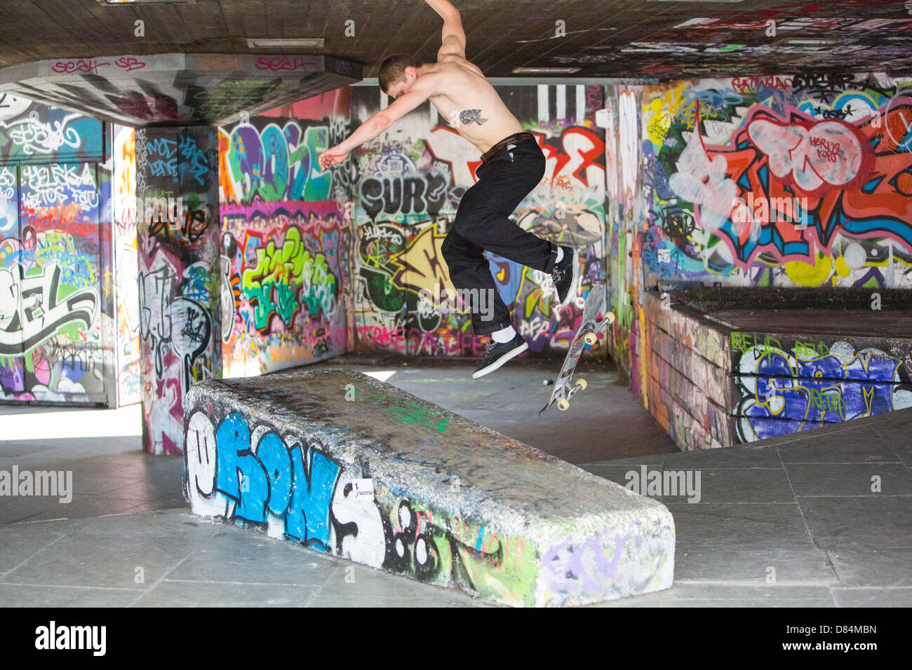 Skateboarders leaping obstacles on London's south Bank. Stock Photo
