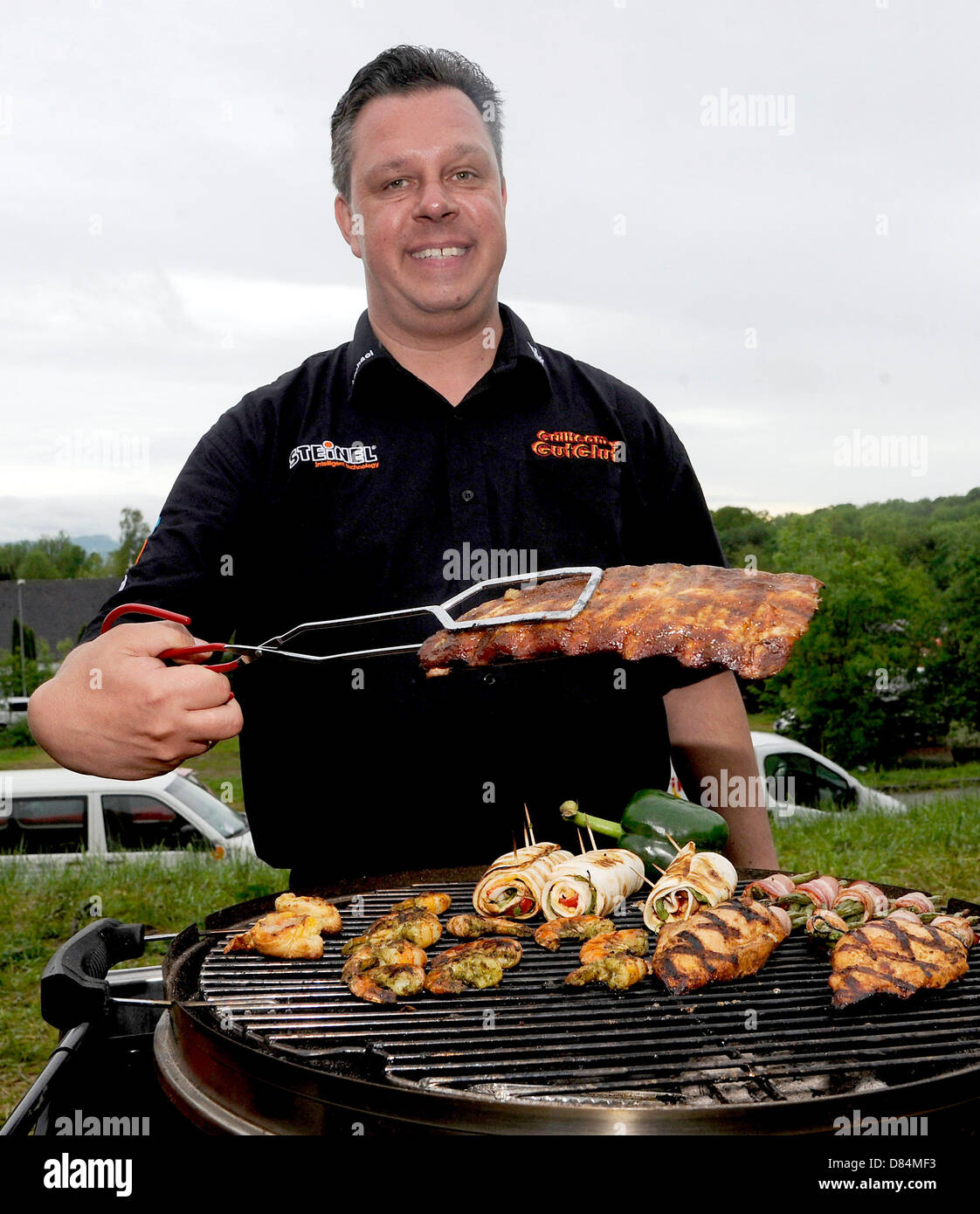 Michael Hoffmann, team boss of Grillteam Gut Glut e.V., presents spare ribs on his grill during the 18th German grill championship in Goeppingen, Germany, 19 May 2013. Hoffman succeeds in defending his championship title from former year, among 32 other teams. PHOTO: DANIEL MAURER Stock Photo