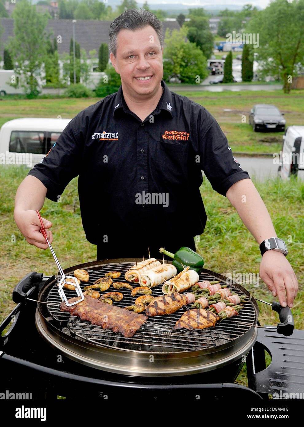Michael Hoffmann, team boss of Grillteam Gut Glut e.V., presents meat on his grill during the 18th German grill championship in Goeppingen, Germany, 19 May 2013. Hoffman succeeds in defending his championship title from former year, among 32 other teams. PHOTO: DANIEL MAURER Stock Photo