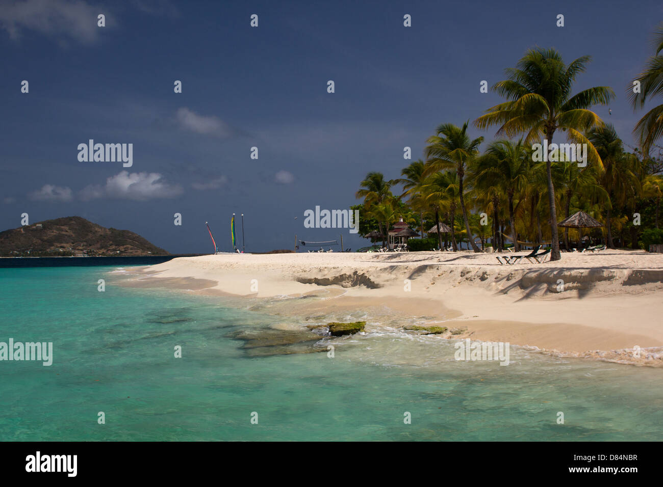 Beautiful Casuarina Beach, Palm Trees, Colourful Caribbean Ocean and Sails. Stock Photo