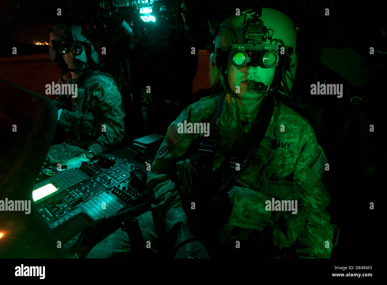 Pilots equipped with night vision goggles in the cockpit of a UH60