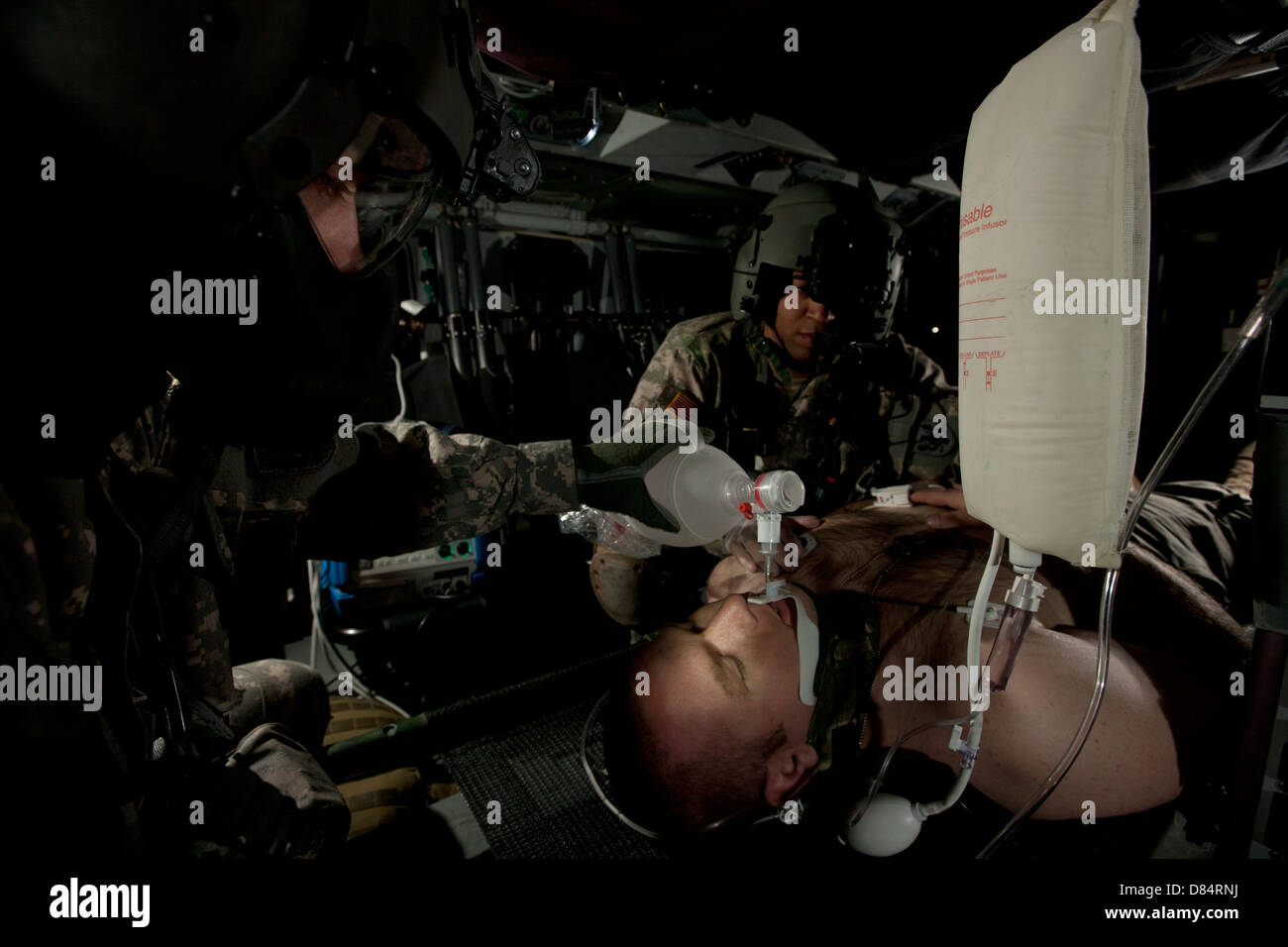 U.S. Army medics simulating ventilation of a mock patient aboard a UH-60 Blackhawk. Stock Photo
