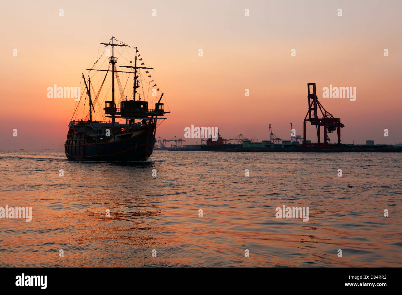 Modern replica of a sailing ship coming to port at sunset in Osaka, Japan. Stock Photo