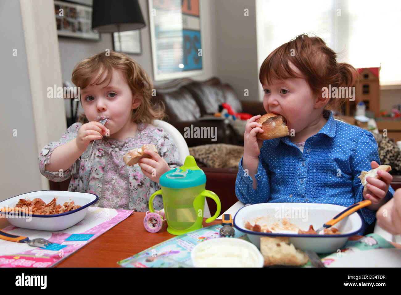 Twins eating pasta Stock Photo - Alamy