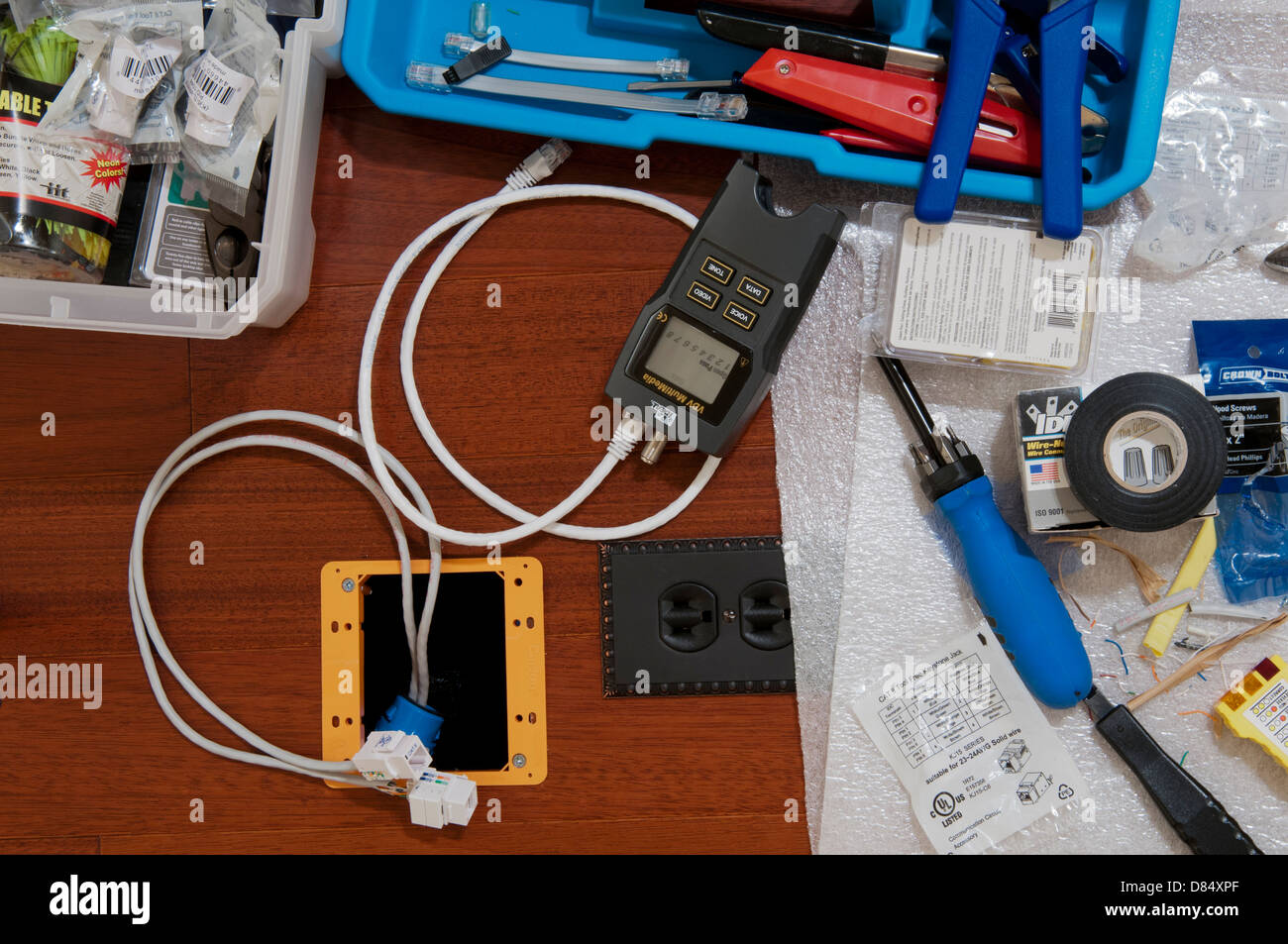 Ethernet wiring tools including a digital line tester during a home office installation. Stock Photo