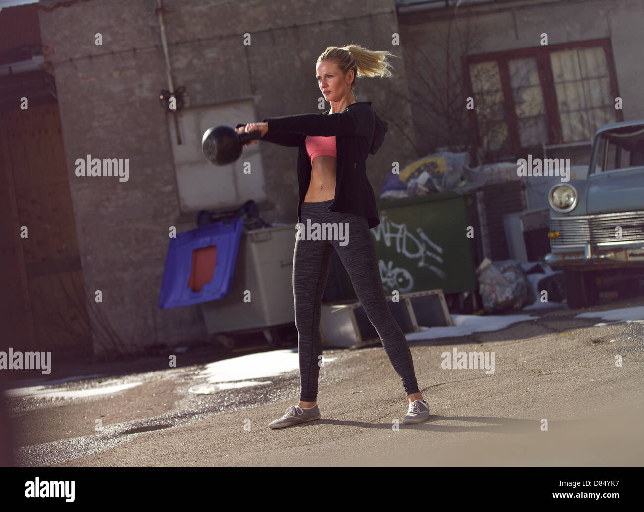 Young fitness woman swinging the kettlebell during crossfit training Stock Photo