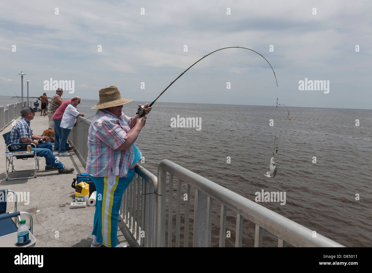 Woman reeling in a fish on the public pier at Cedar Key Florida on the