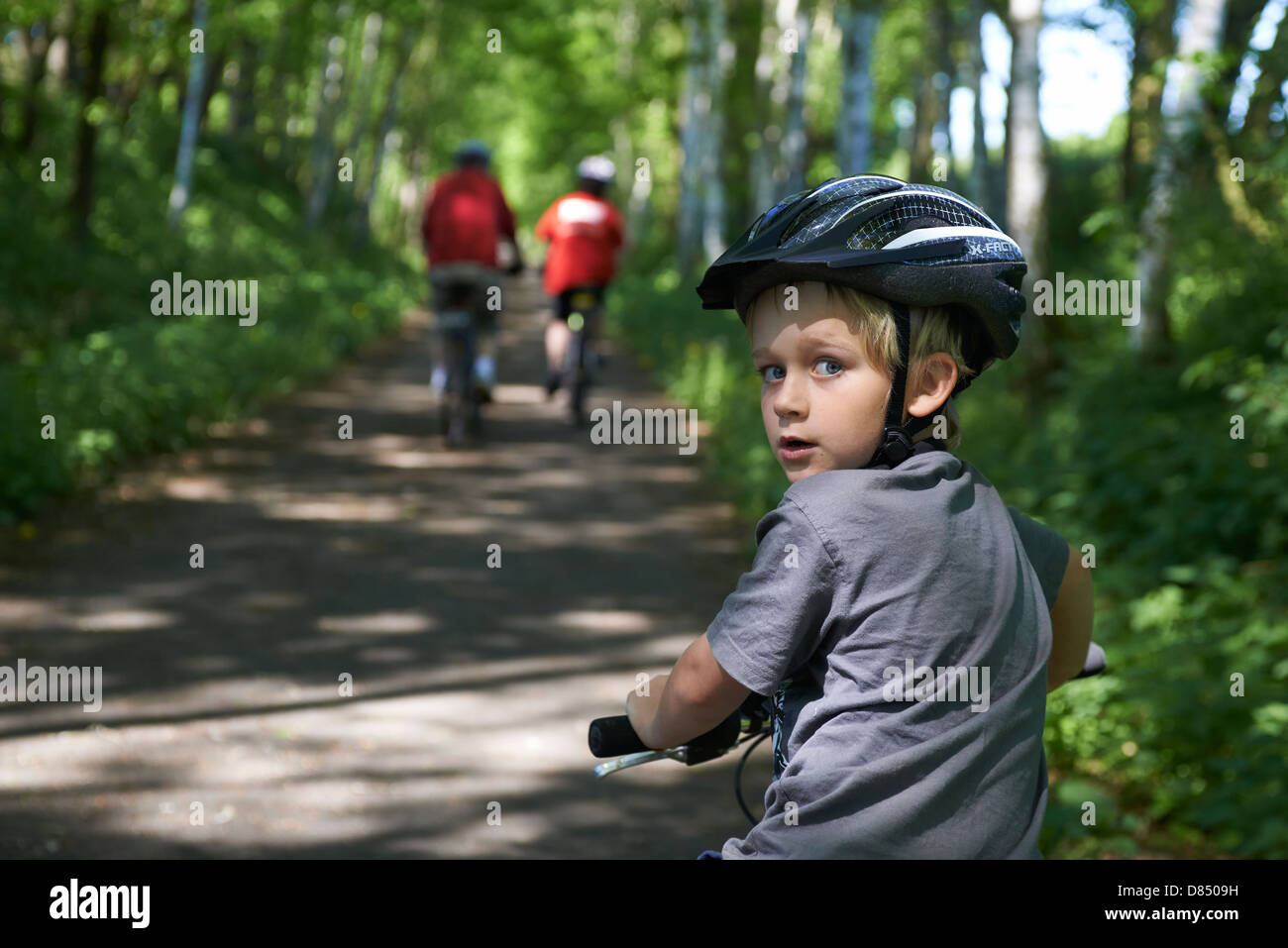 Child blond boy 6 - 7 years old riding bicycle with safety helmet in ...