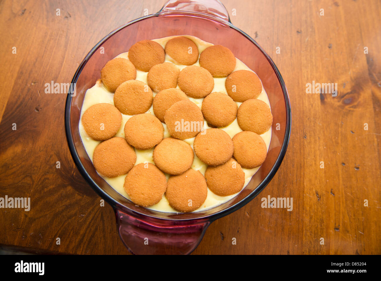 Banana pudding, homemade in a casserole dish. Made with vanilla wafers,vanilla pudding and sliced bananas. On a wooden table. Oklahoma, USA. Stock Photo