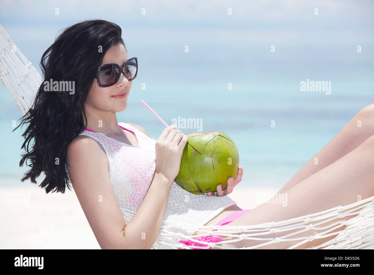 young woman lying in hammock drink. Stock Photo