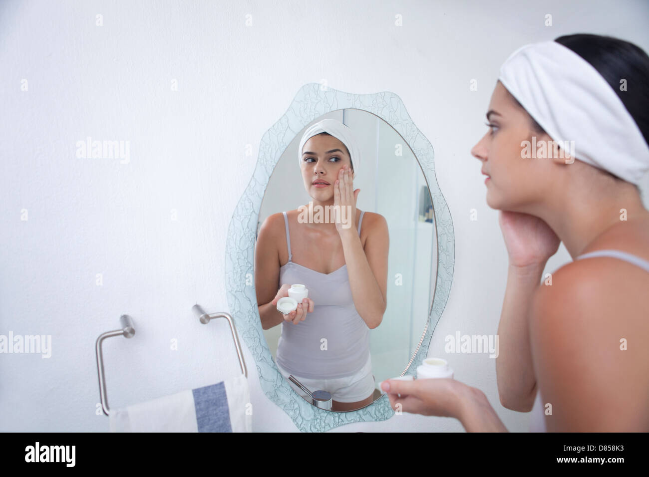 young woman applying face cream. Stock Photo
