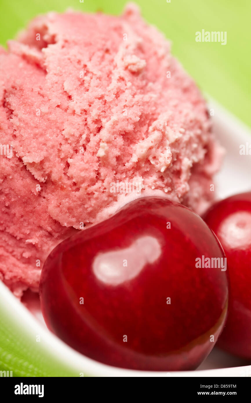 Scoop of delicious cherry ice cream with some cherries Stock Photo
