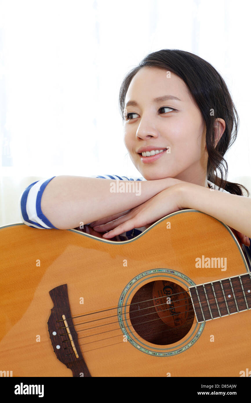 young woman sitting on sofwith acoustic guitar Stock Photo - Alamy